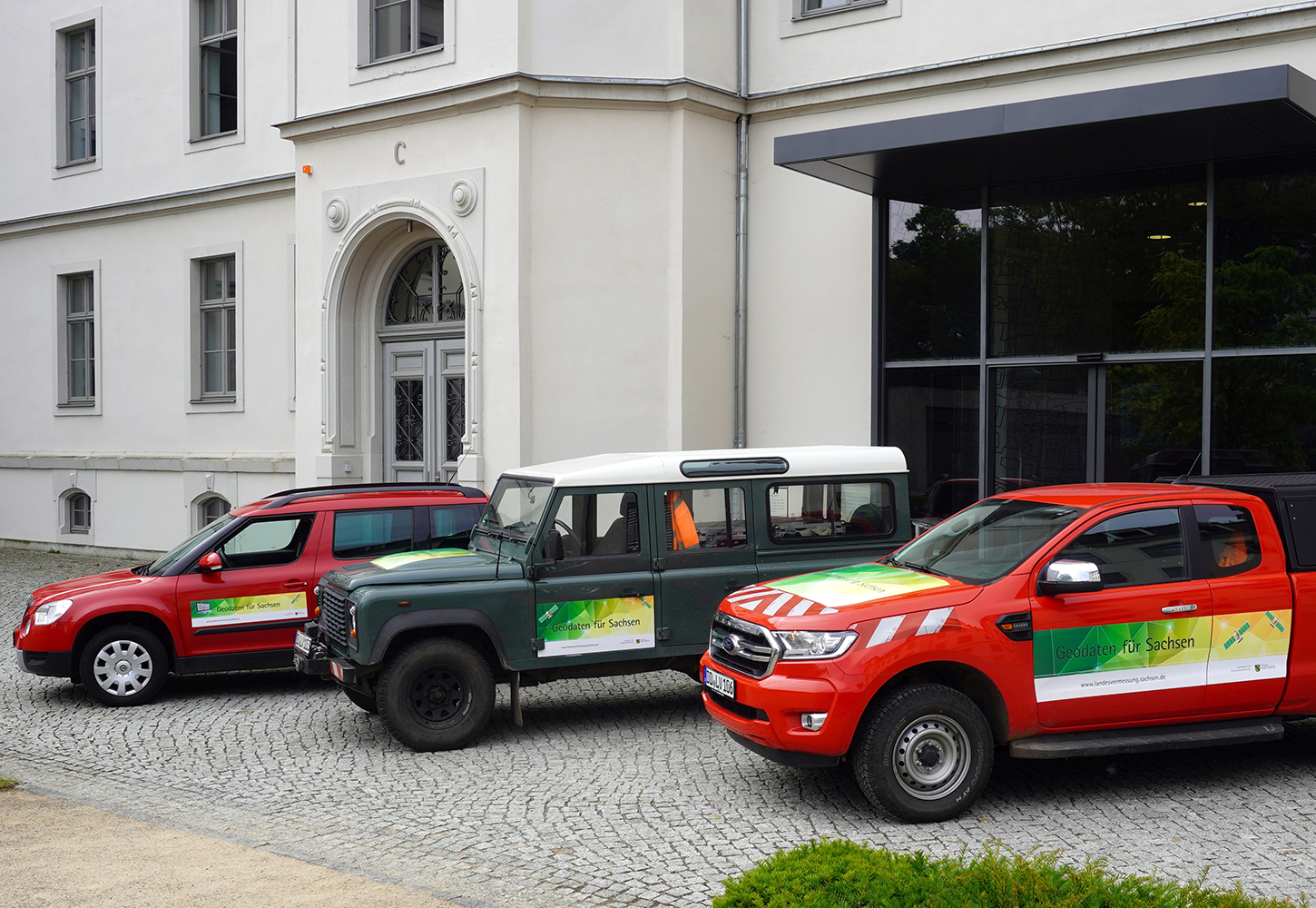 Neu beklebte Fahrzeuge vor dem GeoSN-Eingang